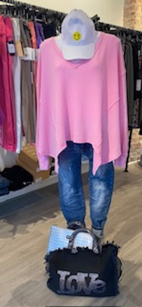 a mannequin wearing a hat with a smiley face, a pink top, blue jeans, and a black bag